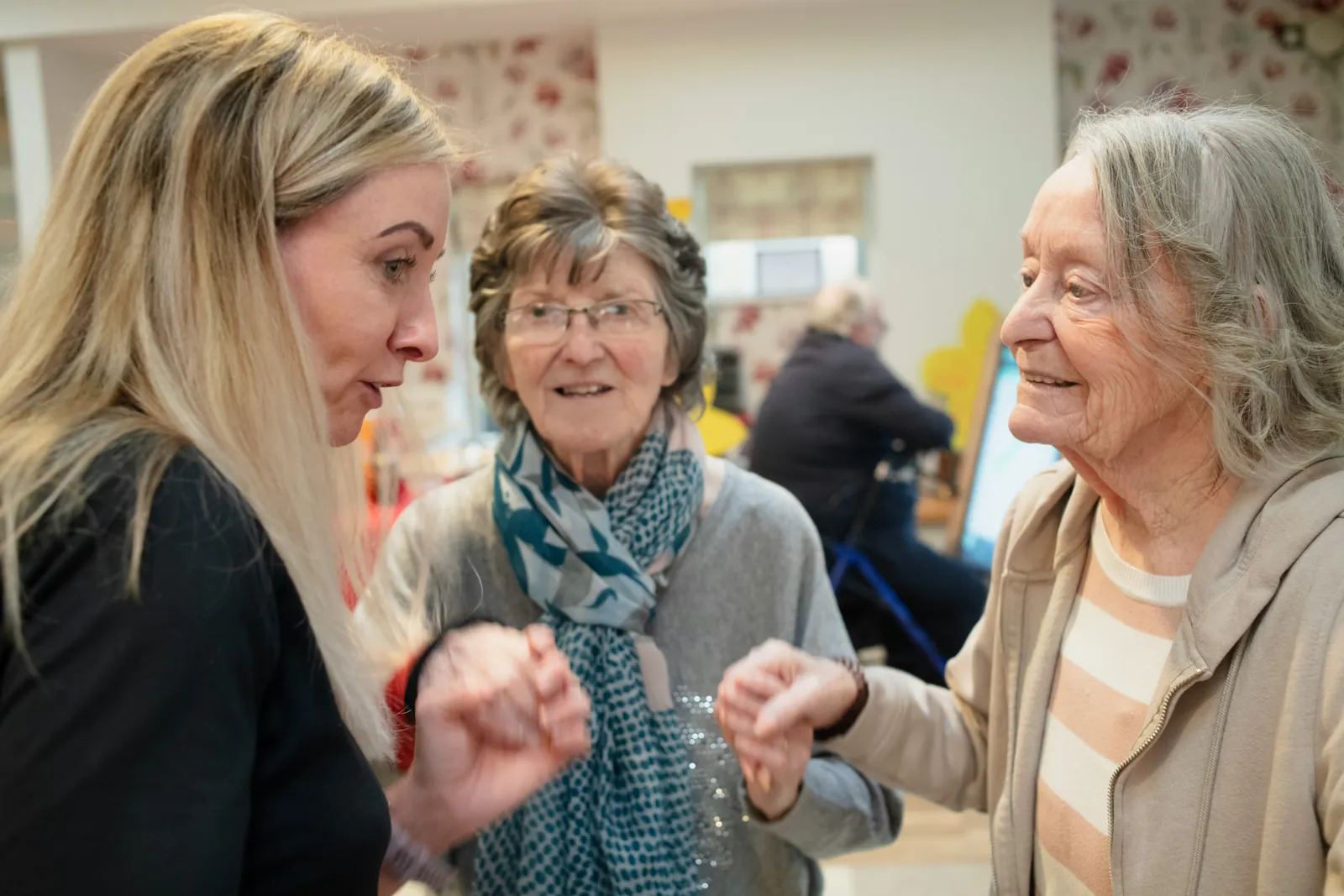 Caregiver speaking with older adults in a supportive setting